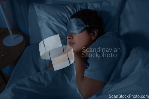 Image of african woman sleeping in bed at home at night