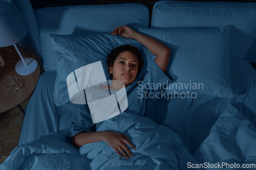 Image of sleepless african woman lying in bed at night