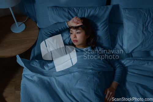 Image of sleepless asian woman lying in bed at night