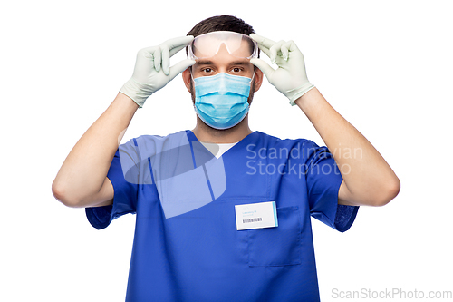 Image of male doctor in goggles, mask and gloves