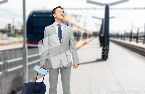 Image of businessman with travel bag on railway station