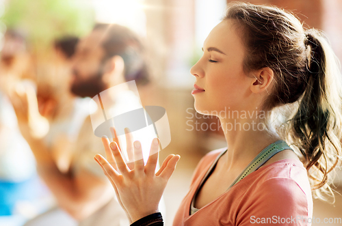 Image of woman with group meditating at yoga studio