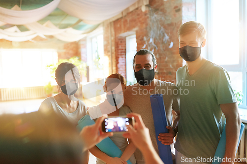 Image of people in masks at yoga studio photographing