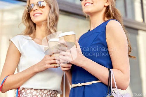 Image of young women with shopping bags and coffee in city