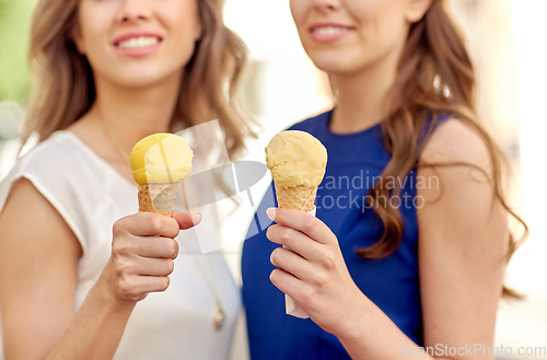 Image of close up of happy women eating ice cream in city