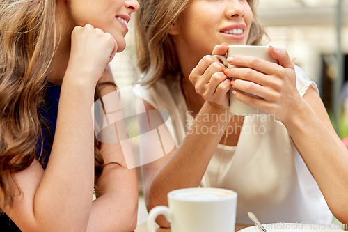 Image of close up of young women with coffee cups at cafe