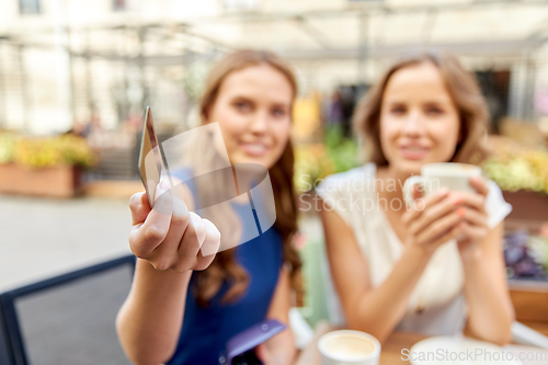 Image of close up of women with credit card at cafe