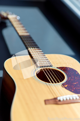 Image of close up of acoustic guitar on window sill