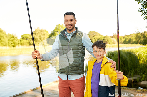 Image of happy smiling father and son fishing on river