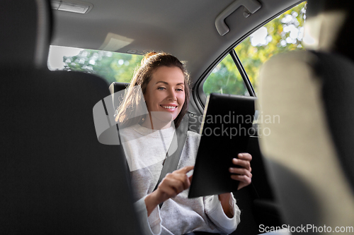 Image of smiling woman in taxi car using tablet pc computer