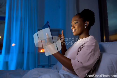 Image of woman with tablet pc having video call at night