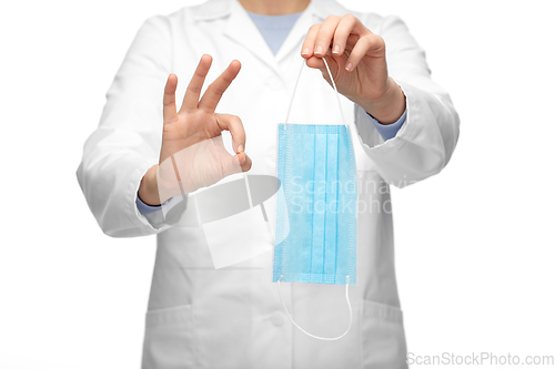 Image of female doctor with medical mask showing ok gesture