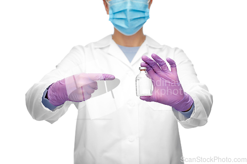 Image of close up of doctor in mask with medicine in bottle