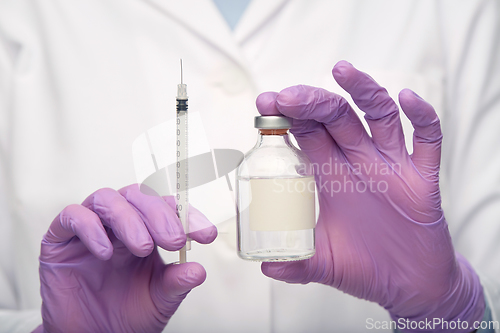 Image of close up of doctor with medicine and syringe