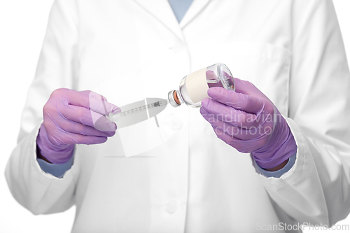 Image of close up of doctor with medicine and syringe