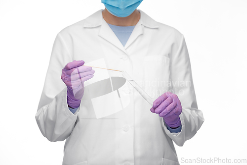 Image of female doctor with test tube and cotton swab