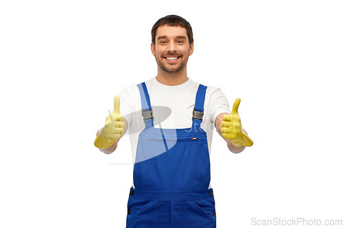 Image of happy male worker or cleaner in overall and gloves