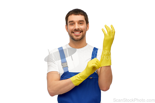 Image of male worker or cleaner in overall wearing gloves