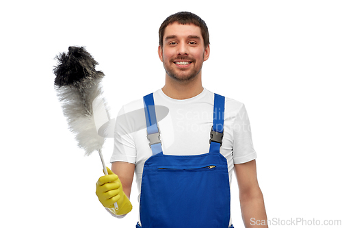 Image of happy male worker or cleaner with duster cleaning