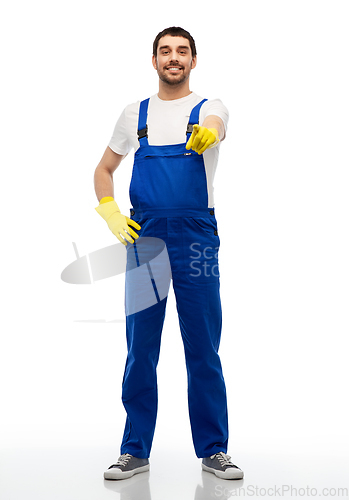 Image of happy male worker or cleaner pointing to you