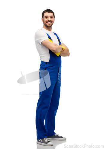 Image of happy male worker or cleaner in overall and gloves