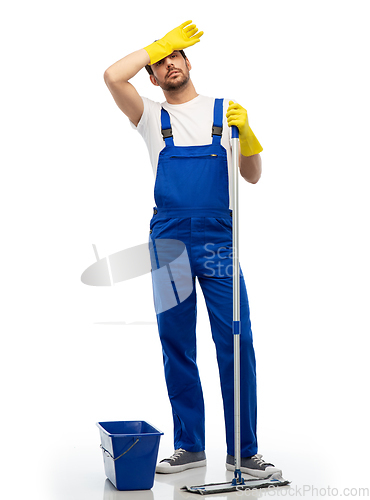 Image of tired cleaner cleaning floor with mop and bucket