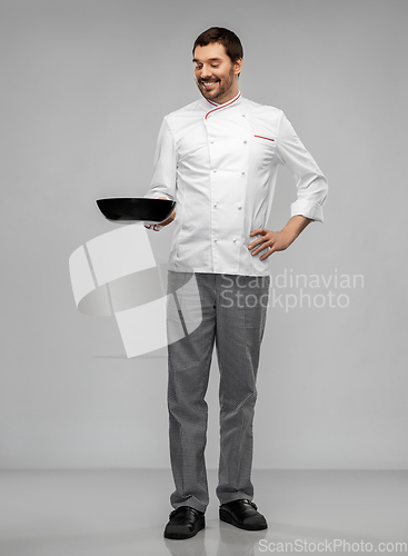 Image of happy smiling male chef in jacket with frying pan