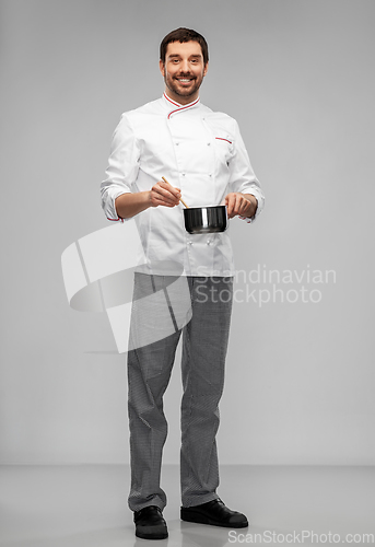Image of happy smiling male chef with saucepan cooking food
