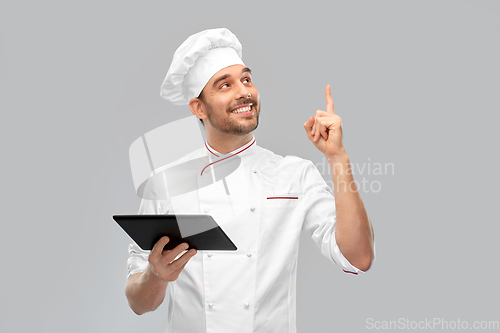 Image of male chef with tablet computer pointing finger up