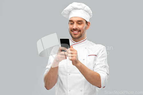 Image of happy smiling male chef with smartphone