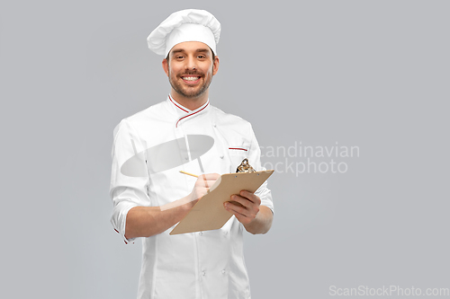 Image of happy smiling male chef with clipboard and pencil