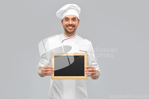 Image of happy smiling male chef showing chalkboard