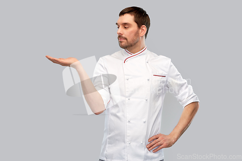 Image of male chef holding something on hand