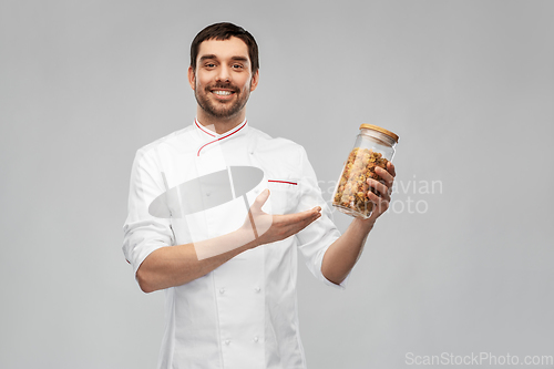 Image of happy smiling male chef with pasta in glass jar