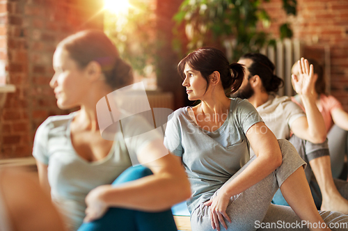 Image of group of people doing yoga exercises at studio