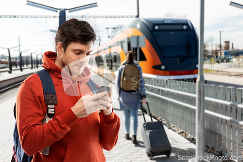 Image of man with smartphone traveling by train