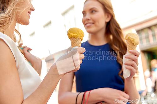 Image of close up of happy women eating ice cream in city