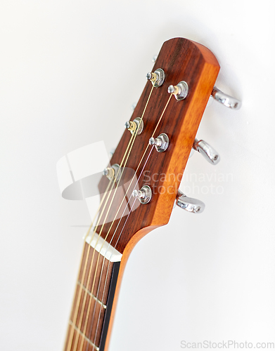 Image of close up of acoustic guitar head with pegs