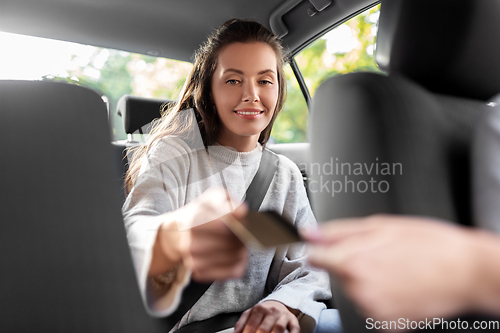 Image of female passenger giving credit card to taxi driver