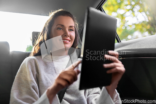 Image of smiling woman in taxi car using tablet pc computer