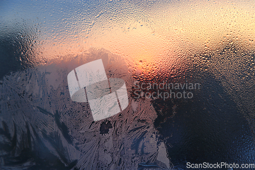 Image of Ice patterns, water drops and sunlight on glass 