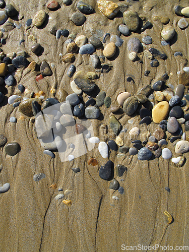 Image of Wet sea pebbles on the wet sand