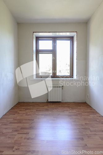 Image of View of the window in a small room after renovation, wood-effect laminate is laid on the floor