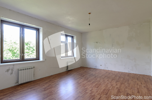 Image of Interior of an empty room during renovation, there are two large windows in the room