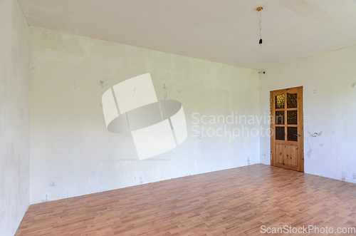 Image of A fragment of the interior of a room with a fine finish, a view of the front door and an empty wall