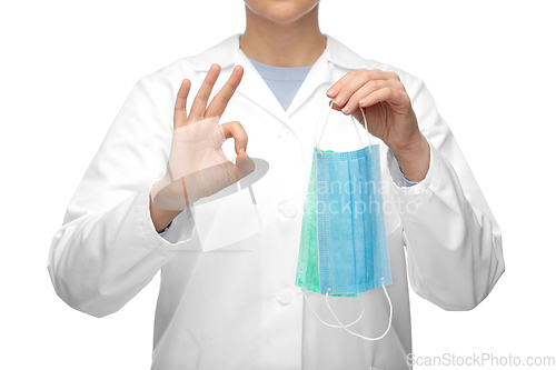 Image of female doctor with medical mask showing ok gesture