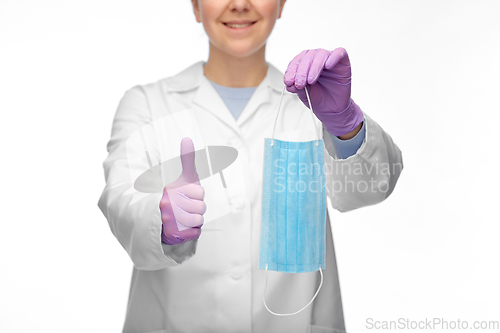 Image of female doctor with medical mask showing thumbs up