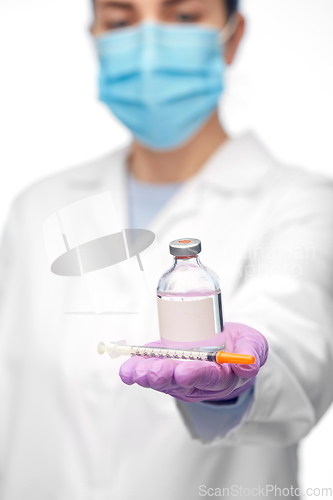 Image of close up of doctor in mask with drug and syringe