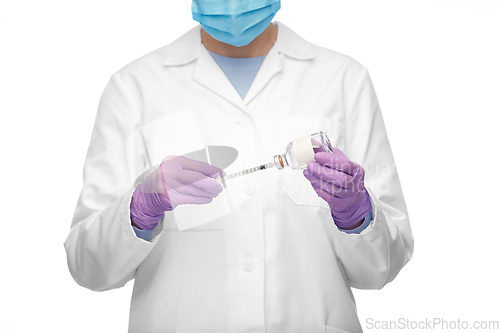 Image of close up of doctor in mask with drug and syringe