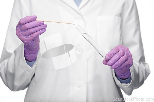 Image of female doctor with test tube and cotton swab